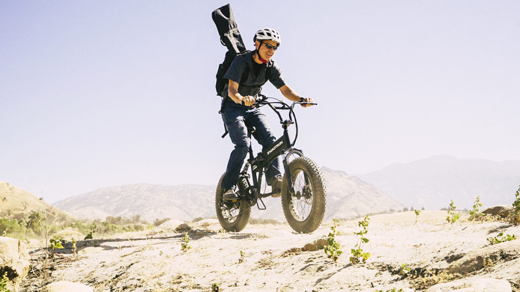 Man wearing a helmet riding an EB8 Fat Tire eBike off road.