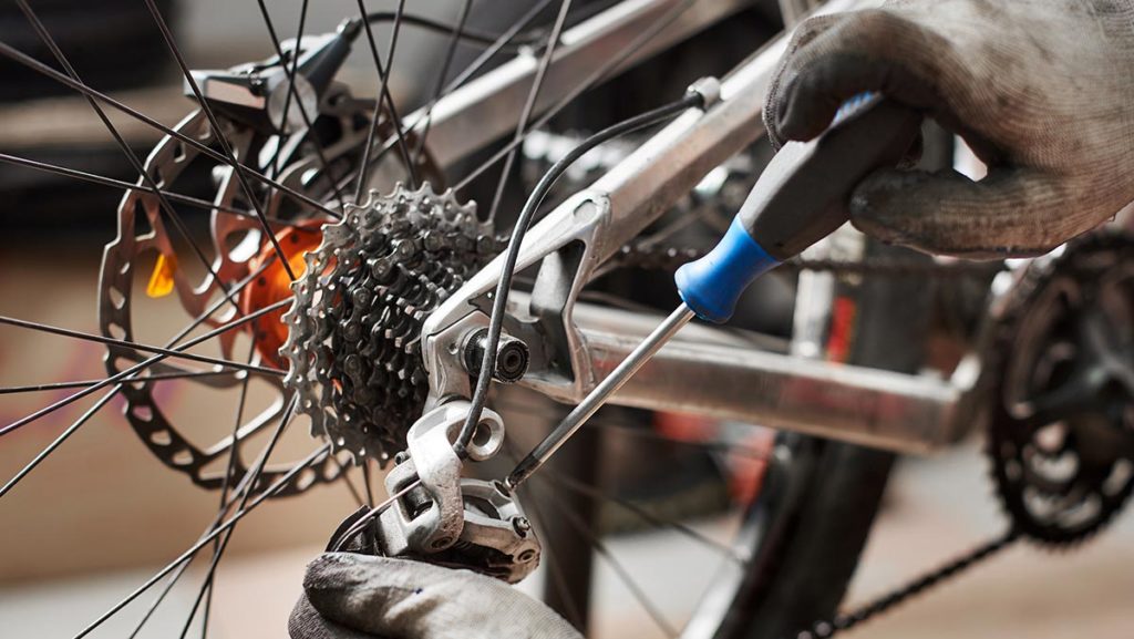 Close-up of a rear gear system of an eBike being worked on by a mechanic.