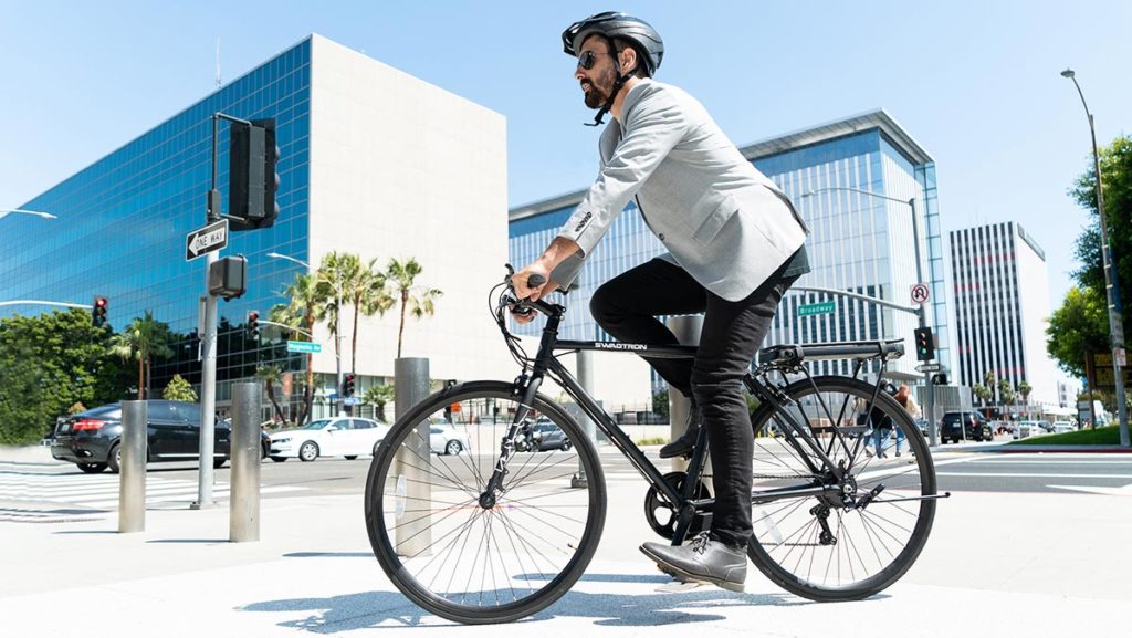 Man wearing a helmet riding an EB12 Road eBike from SWAGTRON.