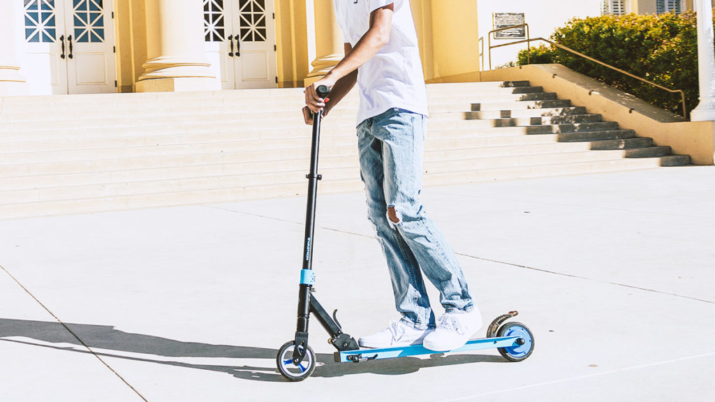 Guy riding on the Swagger 8 Electric Scooter for Kids and Teens.