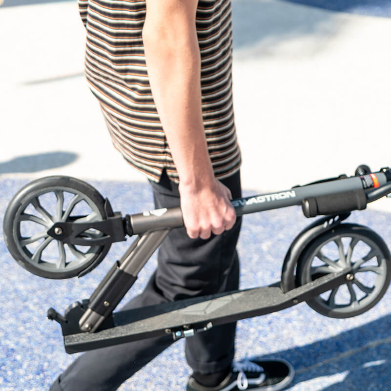 Man walking with his folded kick scooter