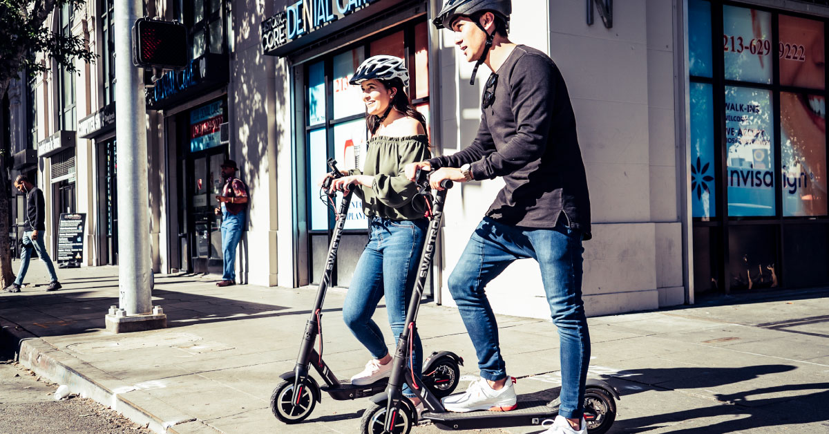 Couple wearing helmets while riding Swagger 5 Elite