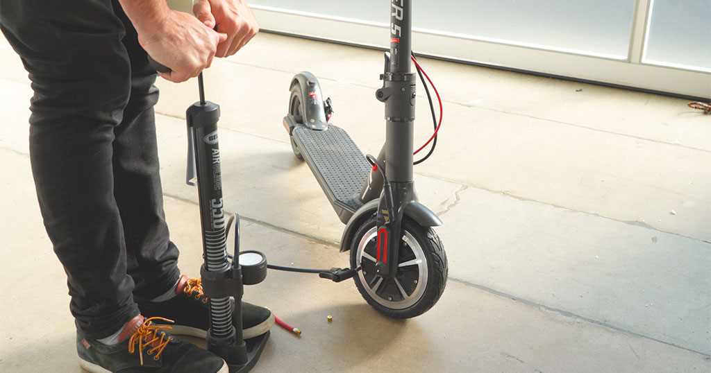 Close-up of man pumping air into the Swagger 5 front tire for proper inflation.