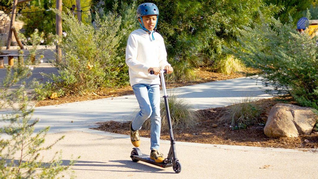 Teen boy wearing a helmet and riding on a Swagger SK3 Glide.