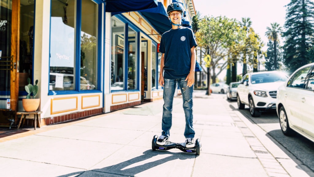 Boy wearing helmet riding a swagBOARD hoverboard.