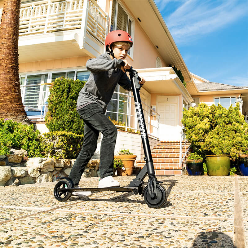 teenager rides his electric scooter around the neighborhood