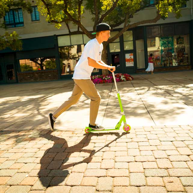 Man with hat on stunt scooter