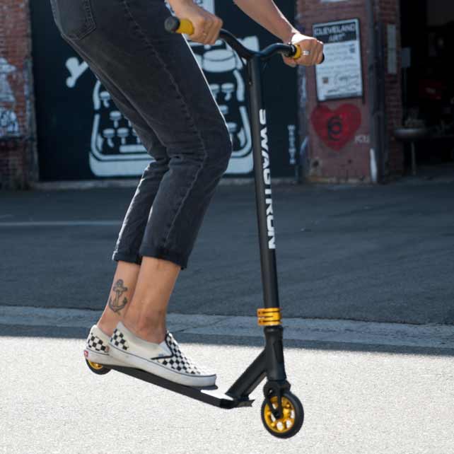 woman with skater shoes on black stunt scooter