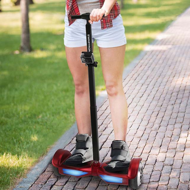 Woman riding hoverboard with handlebar in park