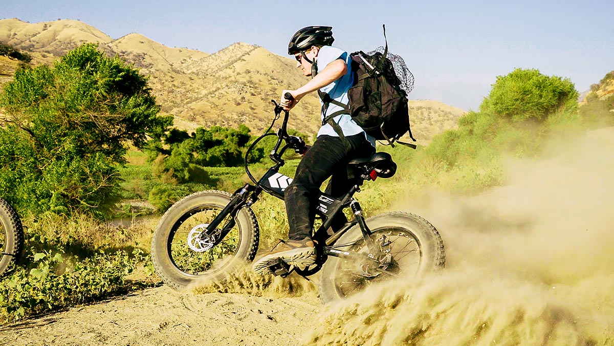 Man wearing helmet, carrying backpack, and trail riding on his EB8 All-Terrain eBike.