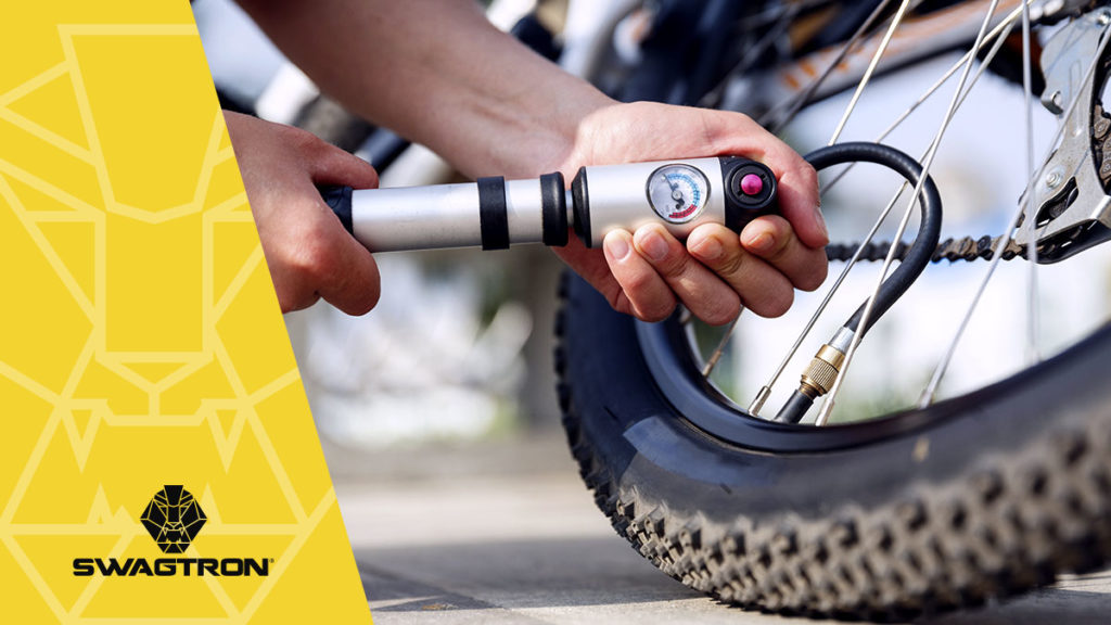 Close-up of man putting air in SWAGTRON eBike tire using an air pump.