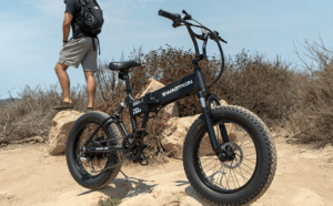 Man resting after riding his electric mountain bike in an off-road trail